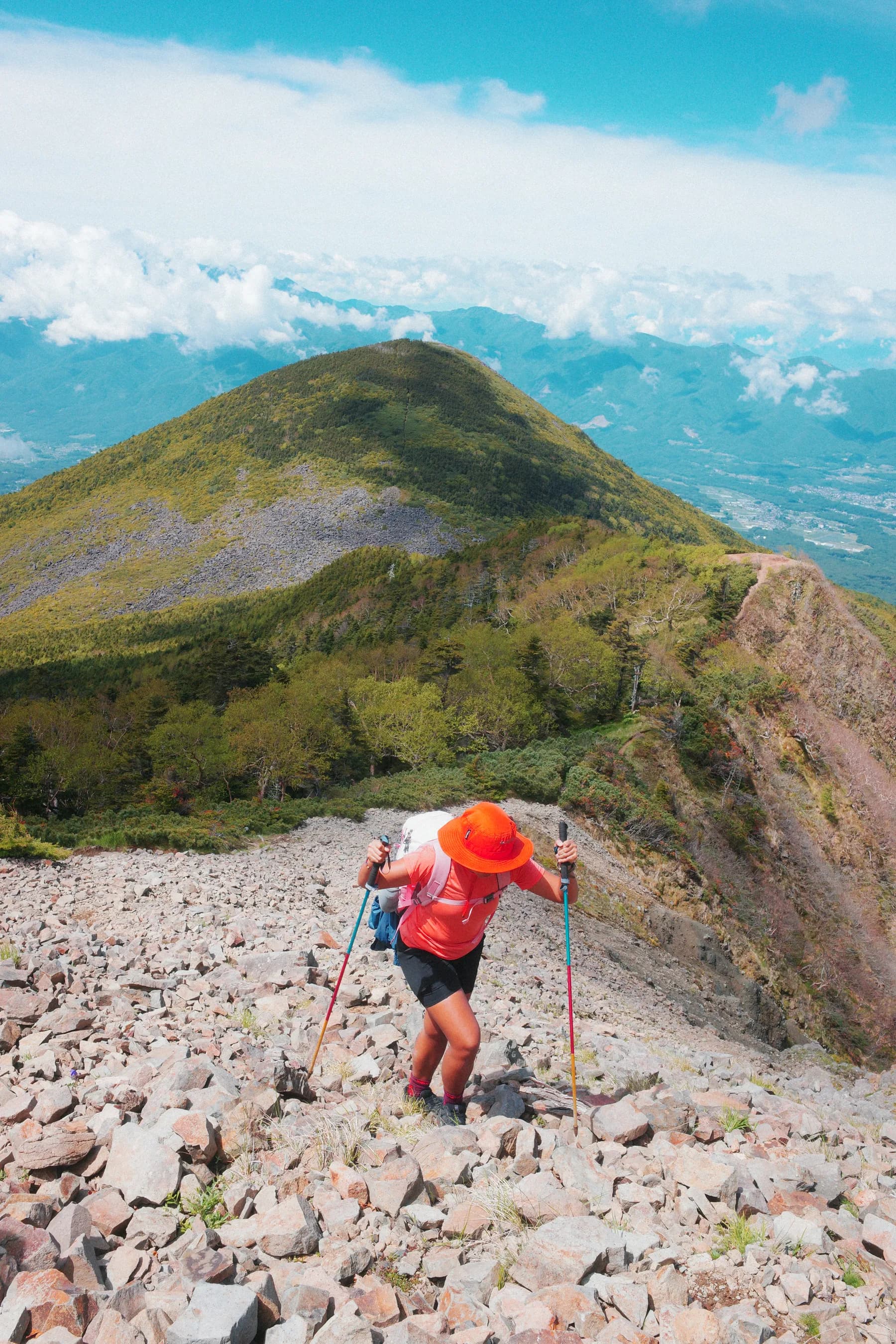 A lone runner on a green ridgeline