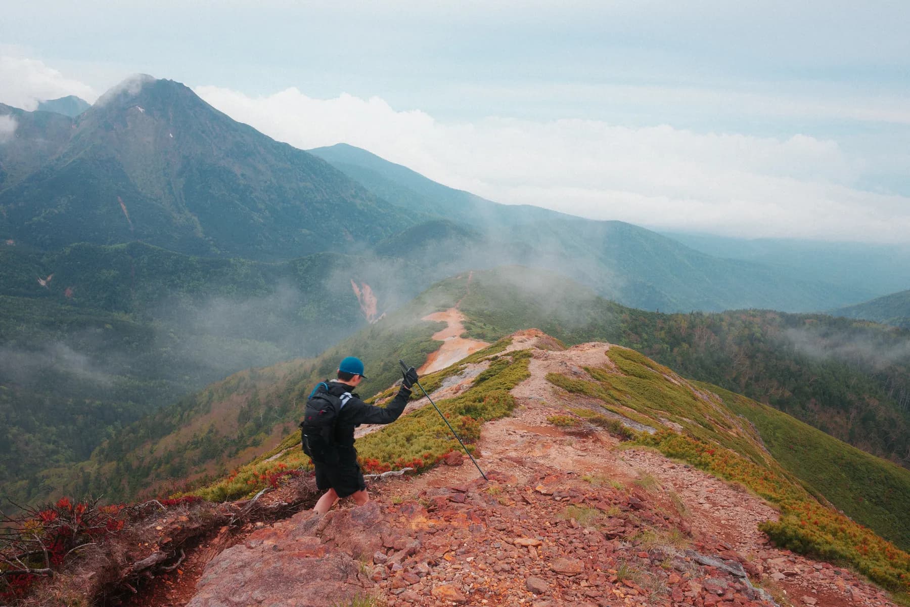 A runner on a misty ridge trail